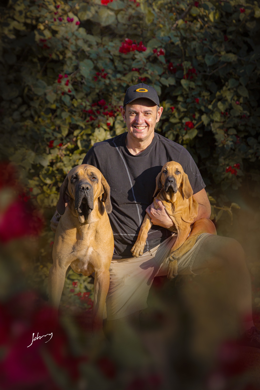 Tutor no jardim com dois cães da família